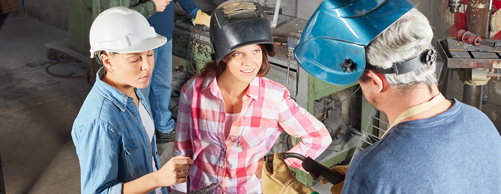 two female welders learning about metal